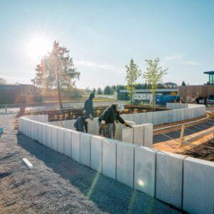 pracownik układa betonową palisadę